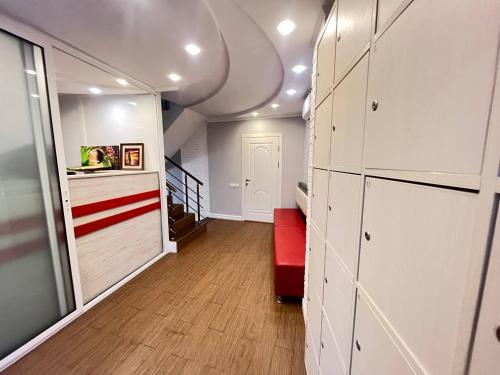 a hallway with white cabinets and a red bench at Like Hostel in Chişinău