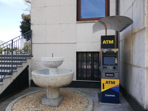 einen Parkuhr neben einem Brunnen vor einem Gebäude in der Unterkunft Hotel La Fontana in Stresa