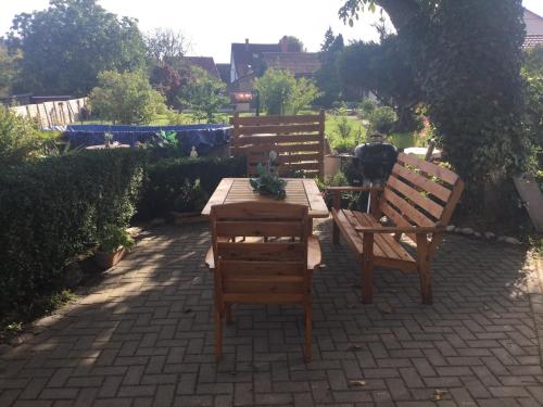 eine Terrasse mit 2 Holzstühlen und einem Tisch in der Unterkunft Ferienwohnung Burgblick in Plaue