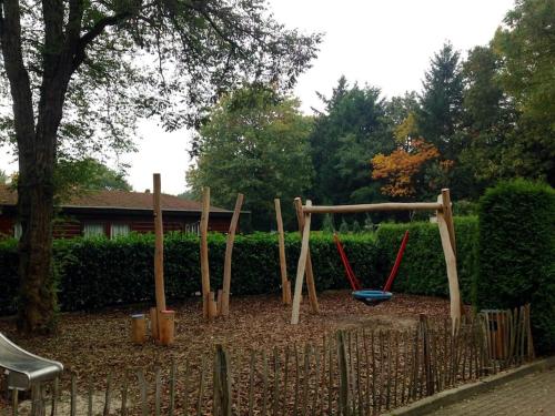 a playground with a swing set in a yard at COSY Holiday Home in Harderwijk