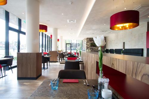 restauracja ze stołem z kwiatem w obiekcie Bastion Hotel Tilburg w mieście Tilburg