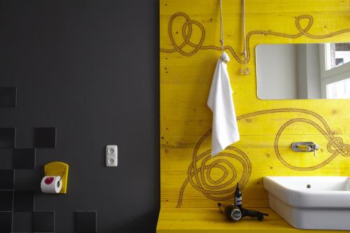 a bathroom with a sink and a mirror at Superbude Hamburg St Pauli in Hamburg