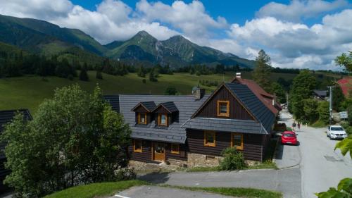 une maison avec des montagnes en arrière-plan dans l'établissement Drevenica Diana, à Ždiar