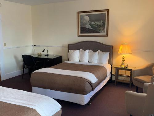 een hotelkamer met een groot bed en een stoel bij Kennedy House in Saint Andrews