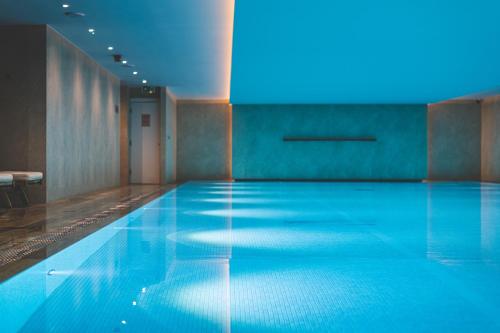 einen Pool in einem Zimmer mit blauer Beleuchtung in der Unterkunft Harbour Hotel & Spa Richmond in Richmond upon Thames