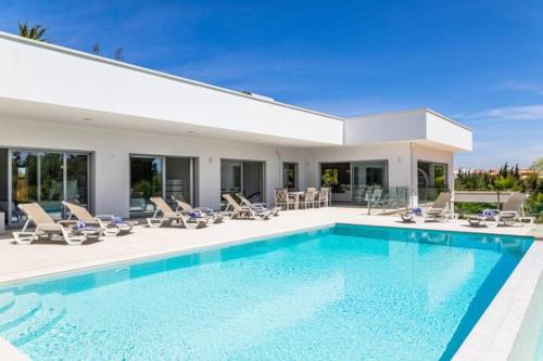 una piscina con sillas y una casa en Fazenda Viegas, en Lagos