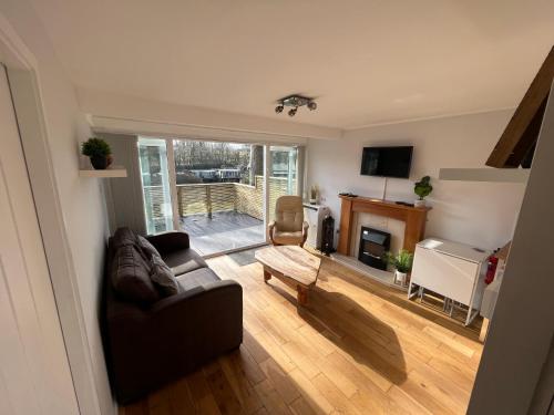 ein Wohnzimmer mit einem Sofa und einem Kamin in der Unterkunft North Wales Lake View 2 Bedroom in Caernarfon