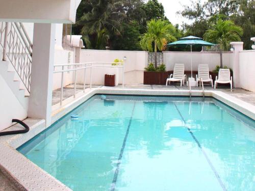 a swimming pool with chairs and an umbrella at Holiday Saipan Hotel in Saipan