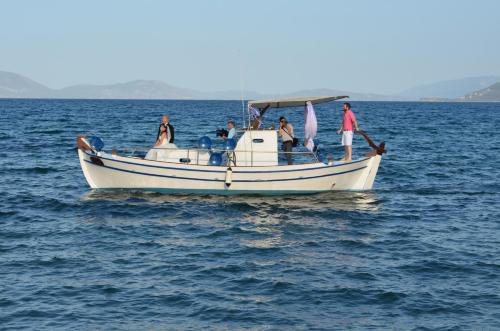 un groupe de personnes sur un bateau dans l'eau dans l'établissement Mouria Pension Rooms & Studios, à Ancient Epidavros