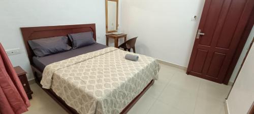 1 dormitorio con cama, mesa y puerta en Pranav 4 Seasons, en Munnar