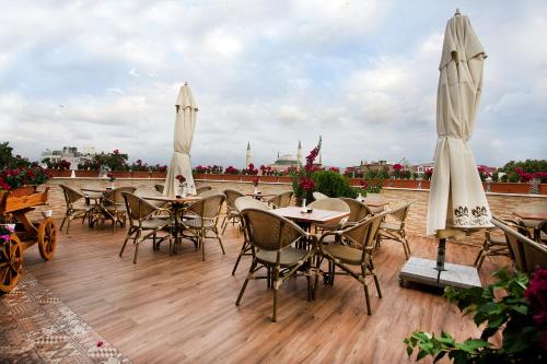 a patio with tables and chairs and umbrellas at White House Hotel Istanbul in Istanbul