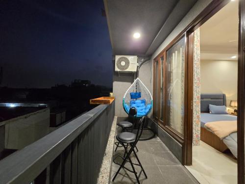 Cette chambre dispose d'un balcon avec un lit et un tabouret. dans l'établissement Homlee-Saket Anupam Stylish 3BHK in South Delhi, à New Delhi