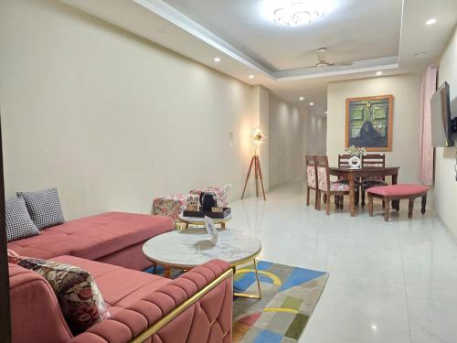 un salon avec un canapé et une table ainsi qu'une salle à manger dans l'établissement Homlee-Saket Anupam Stylish 3BHK in South Delhi, à New Delhi