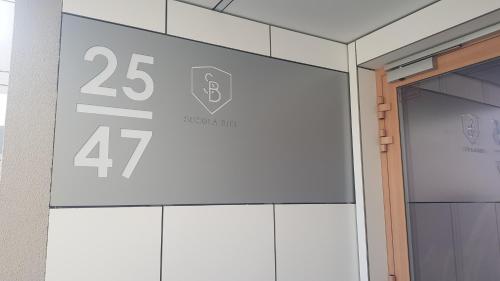 een bord aan de zijkant van een gebouw met nummers erop bij Apartament Flat 33 Suwałki in Suwałki