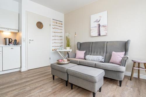 a living room with a couch and a table at Möwennest App 18 in Wenningstedt