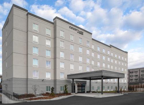 un gran edificio blanco con dosel en un aparcamiento en Courtyard by Marriott Seattle SeaTac Airport, en Seattle