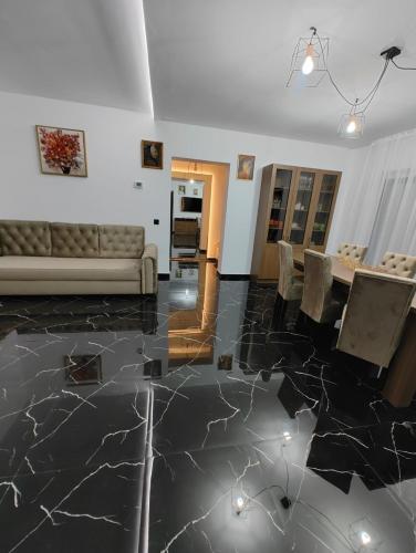 a living room with a marble floor and a couch at Black&White House in Ocna-Mureşului