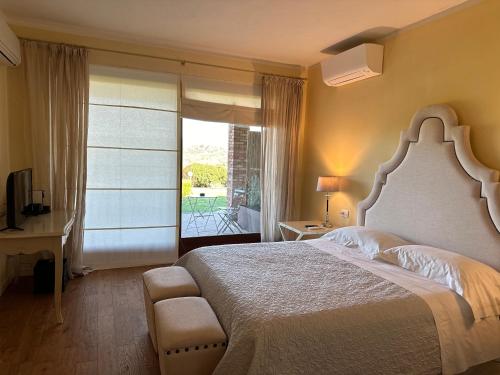 1 dormitorio con 1 cama grande y balcón en Saturnia Country Villas, en Saturnia