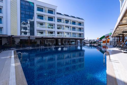 um edifício com piscina em frente a um edifício em Belenli Resort Hotel em Belek