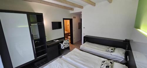 - une chambre avec un lit et un grand miroir dans l'établissement Ecohotel Primavera, à Riva del Garda