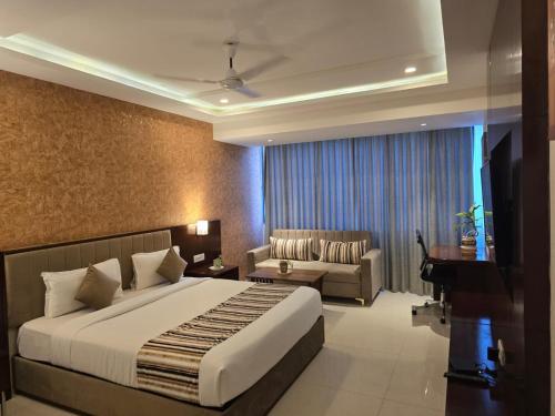 a hotel room with a bed and a couch at KAMAT'S DAFFODIL RESORT GOA in Pilerne