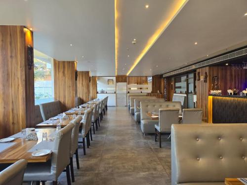 a dining room with tables and chairs in a restaurant at KAMAT'S DAFFODIL RESORT GOA in Pilerne