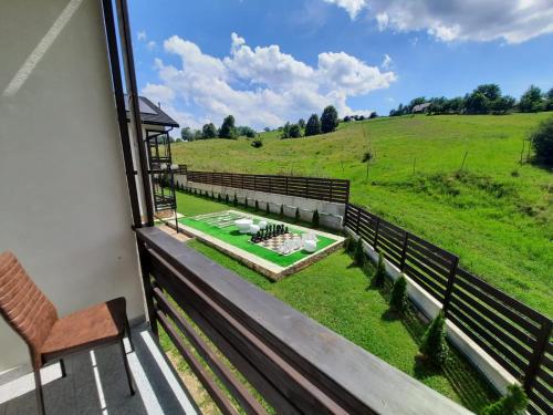 balcone con sedia e vista su un campo di Sat de Vacanta Martisorul Cacica a Suceava