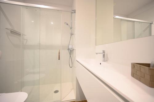 bagno bianco con doccia e lavandino di Casa Guerreiro - Regina Hotel Group a Viana do Castelo