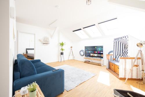 een woonkamer met een blauwe bank en een tv bij Ko-Living - Captain's Suite - Altstadt - mit Küche, Smart TV & Balkon - 6P in Halle an der Saale