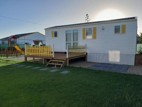 a small white house with a deck and a playground at Casinhas dos Valados in Atouguia da Baleia