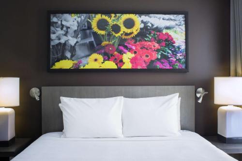 ein Schlafzimmer mit einem Bett mit einem Blumengemälde in der Unterkunft Hyatt House New York/Chelsea in New York