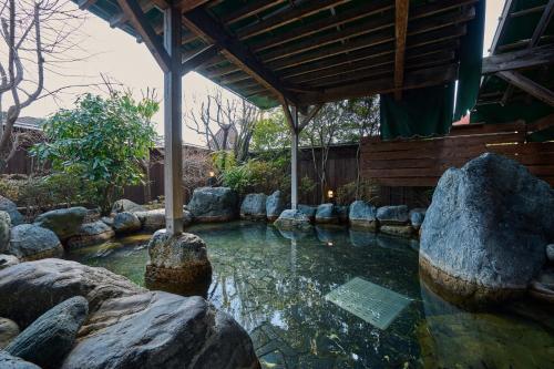 una piscina di acqua con rocce in un giardino di Royal Hotel Kawaguchiko a Fujikawaguchiko