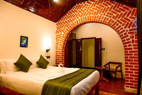 una camera con un letto in una stanza con un muro di mattoni di Coorg Mystere - Luxury Homestay a Madikeri