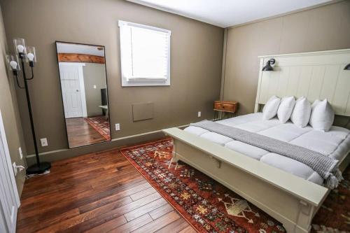 - une chambre avec un grand lit et un miroir dans l'établissement Modern & Cozy Getaway House near Conway lake - Pet Friendly, à Conway