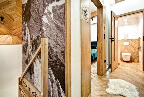 a hallway with a wall mural of a mountain at Domki pod Grapą JAKUZZI & DELUXE & Willa pod Grapą in Poronin