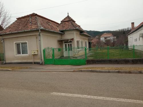 dom z zieloną bramą obok ulicy w obiekcie Casa Ani w mieście Ocna Mureş