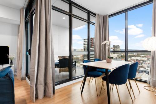 une salle à manger avec une table, des chaises et une grande fenêtre dans l'établissement The elegant 1BR CBD Apt - City view - Parking, à Adélaïde