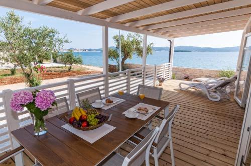 uma mesa de madeira com uma taça de fruta num deque em San Antonio mobile homes em Biograd na Moru