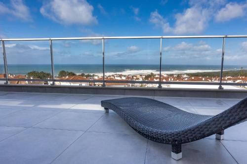 un banc au-dessus d'un bâtiment avec vue sur l'océan dans l'établissement Océane Guest House - Adults only, à Nazaré