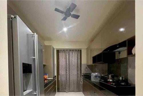 Il comprend une cuisine équipée d'un ventilateur de plafond. dans l'établissement Endora homestay - A fully equipped lake-facing 3BHK, à Lavasa