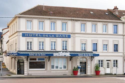 オータンにあるContact Hôtel de la Gare et son restaurant Côte à Côteの青い看板が貼られたホテルの建物