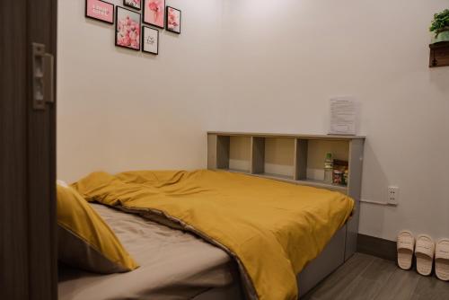 uma cama com um edredão amarelo num quarto em Halidao Homestay em Hai Phong