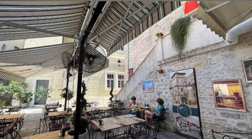 2 personnes assises à une table dans un restaurant dans l'établissement Little Bay Apartments, à Kotor