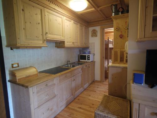 a kitchen with wooden cabinets and a sink at Appartamento Brentegani in Arabba