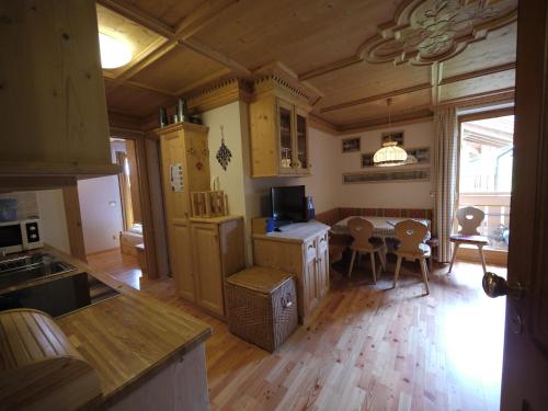 a kitchen with wooden cabinets and a table with chairs at Appartamento Brentegani in Arabba