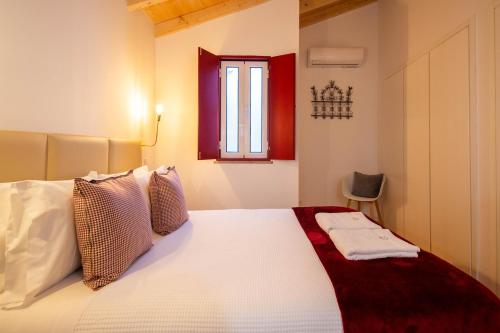 1 dormitorio con cama blanca y ventana en Sefardita - Guest House, en Castelo de Vide