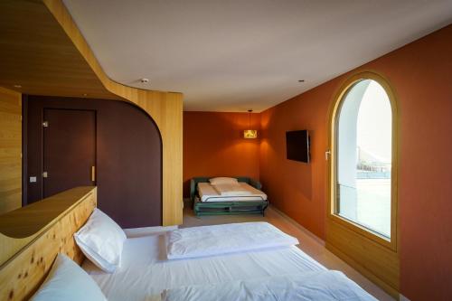 a bedroom with two beds and an arched window at Hotel La Briosa in Bolzano