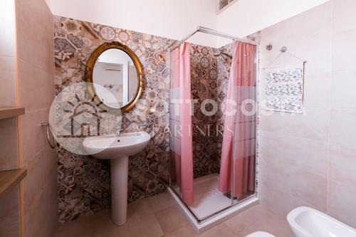 y baño con lavabo, espejo y ducha. en Floral Flat - Porto Cesareo, en Porto Cesareo