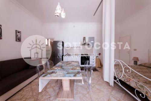 sala de estar con mesa y sofá en Floral Flat - Porto Cesareo, en Porto Cesareo