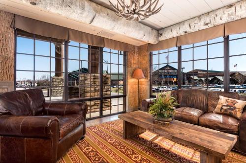 sala de estar con muebles de cuero y ventanas grandes. en Bass Pro Shops Angler's Lodge, en Springfield